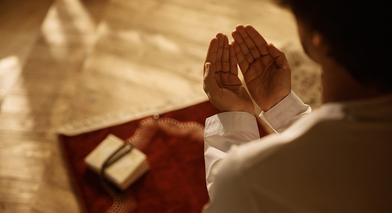 Close up of Muslim believer reciting dua during prayer at home.